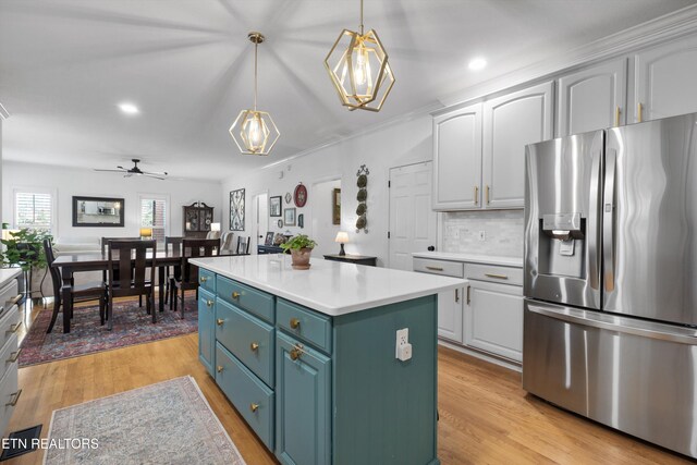 kitchen with pendant lighting, stainless steel refrigerator with ice dispenser, light hardwood / wood-style flooring, a kitchen island, and white cabinetry