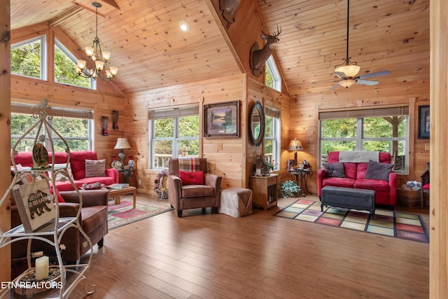 living room featuring a healthy amount of sunlight, ceiling fan with notable chandelier, and high vaulted ceiling