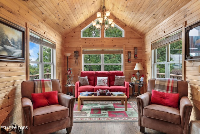 living room with an inviting chandelier, wooden walls, and hardwood / wood-style flooring