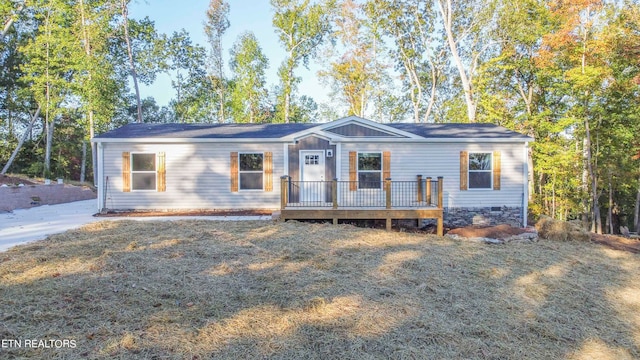 ranch-style house featuring a wooden deck and a front lawn