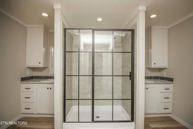 bathroom featuring vanity, hardwood / wood-style floors, an enclosed shower, and crown molding