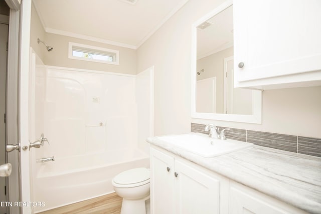 full bathroom with toilet, hardwood / wood-style floors, shower / bathtub combination, ornamental molding, and vanity