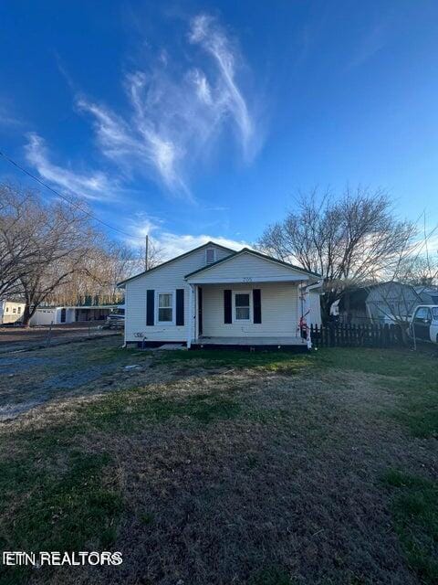 view of front of property featuring a front lawn and fence