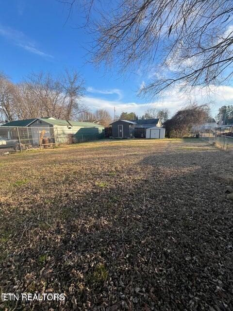 view of yard with a storage shed, fence, and an outdoor structure