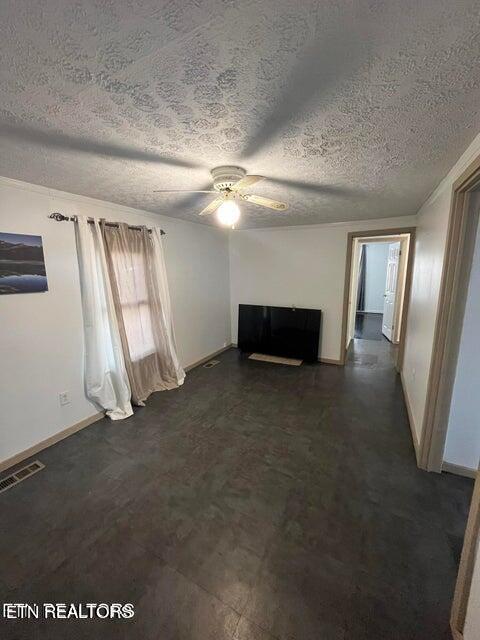 unfurnished living room with ceiling fan, a textured ceiling, visible vents, and baseboards