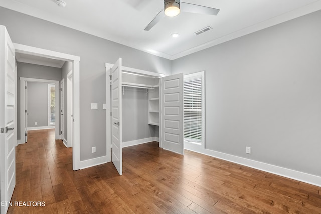 unfurnished bedroom with a closet, ornamental molding, wood-type flooring, and ceiling fan