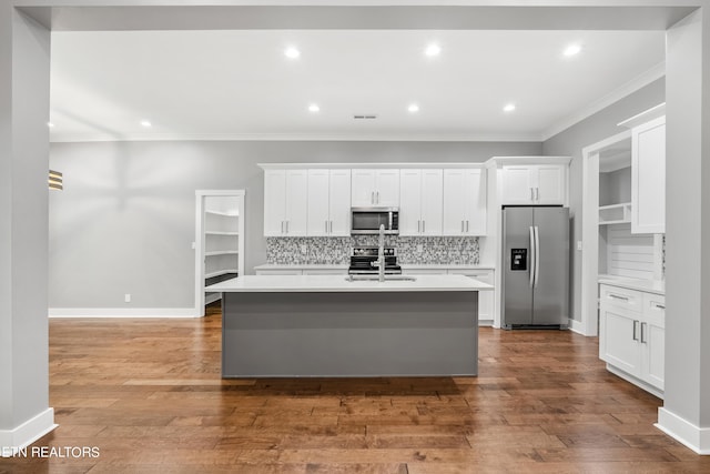 kitchen with hardwood / wood-style flooring, stainless steel appliances, a kitchen island with sink, and white cabinets