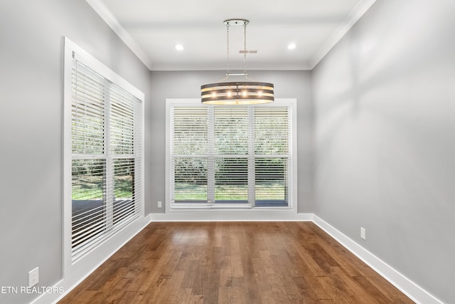 unfurnished dining area featuring crown molding, hardwood / wood-style floors, and a chandelier