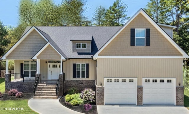 craftsman inspired home featuring a garage and a porch