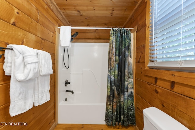 bathroom with wood walls, shower / bathtub combination with curtain, wooden ceiling, and toilet