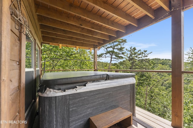 view of patio with a balcony and a hot tub