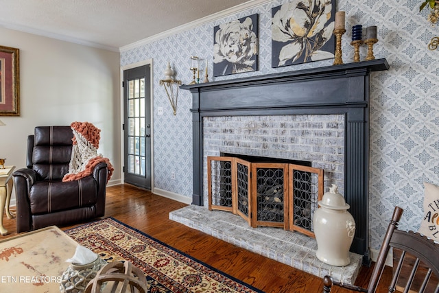 living area featuring a brick fireplace, wallpapered walls, crown molding, and a textured ceiling