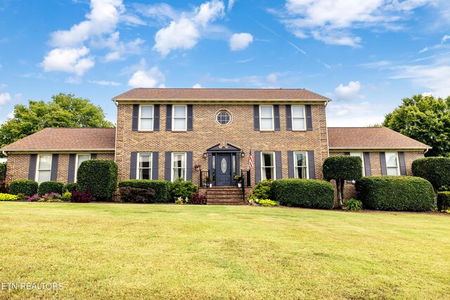 colonial house featuring a front lawn