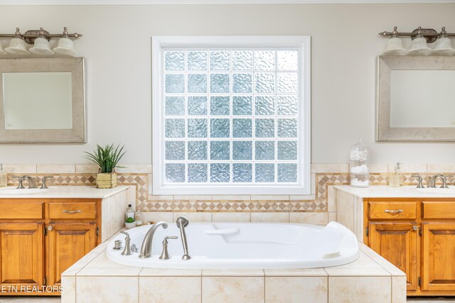 bathroom with vanity and tiled tub