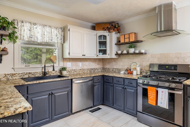 kitchen featuring ornamental molding, a sink, white cabinets, appliances with stainless steel finishes, and wall chimney exhaust hood