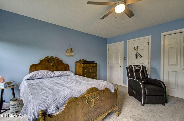 carpeted bedroom featuring a textured ceiling and ceiling fan