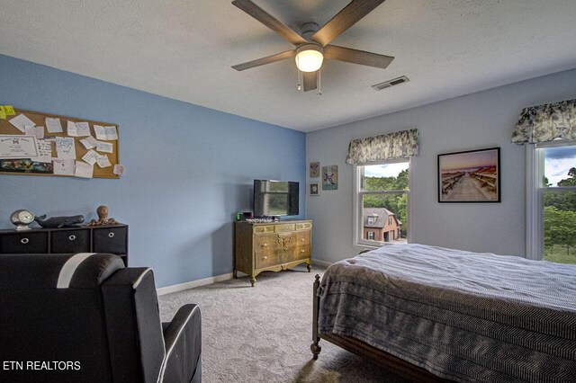 bedroom featuring ceiling fan, carpet, and a textured ceiling