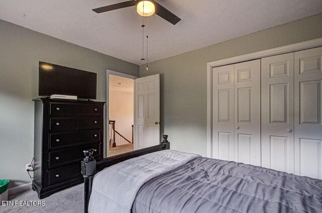 bedroom featuring a textured ceiling, carpet, ceiling fan, and a closet