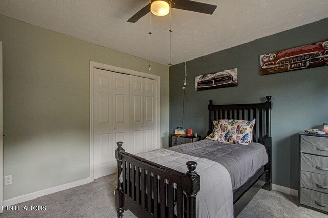 bedroom with a closet, a textured ceiling, ceiling fan, and carpet