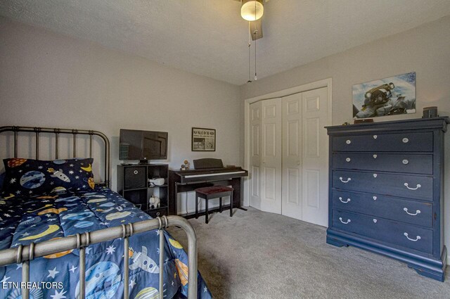 carpeted bedroom featuring a textured ceiling, ceiling fan, and a closet