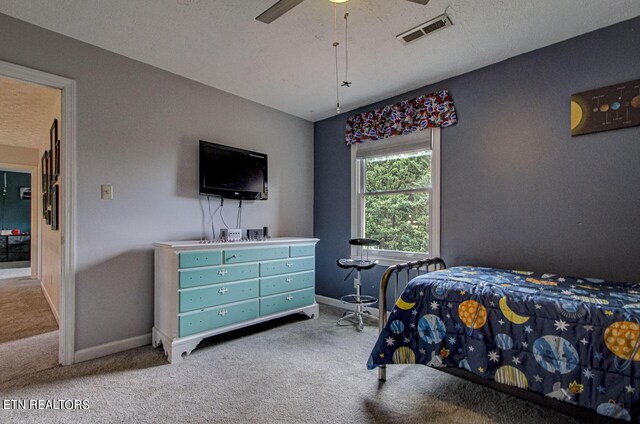 bedroom with a textured ceiling, carpet flooring, and ceiling fan