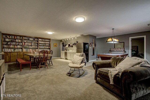 carpeted living room featuring billiards, track lighting, and a textured ceiling