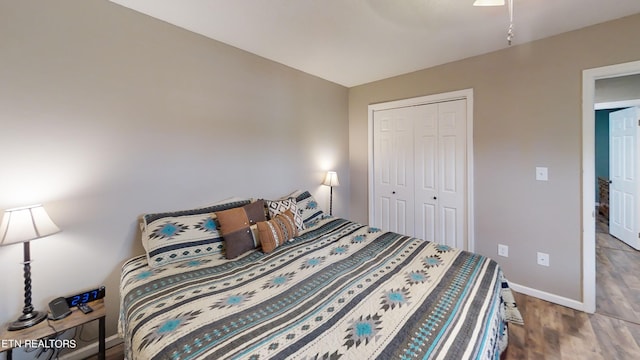 bedroom featuring wood-type flooring, ceiling fan, and a closet