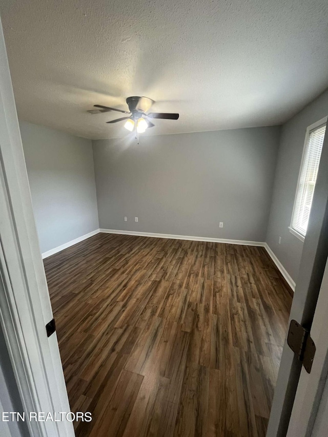 empty room featuring a textured ceiling, ceiling fan, and dark hardwood / wood-style floors