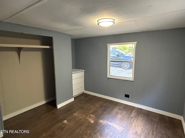 unfurnished bedroom featuring dark hardwood / wood-style flooring and a closet