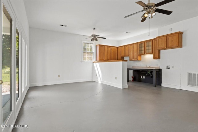 unfurnished living room with ceiling fan and concrete floors