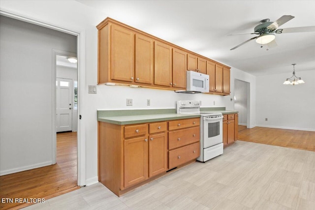 kitchen featuring ceiling fan with notable chandelier, light wood-type flooring, white appliances, and hanging light fixtures