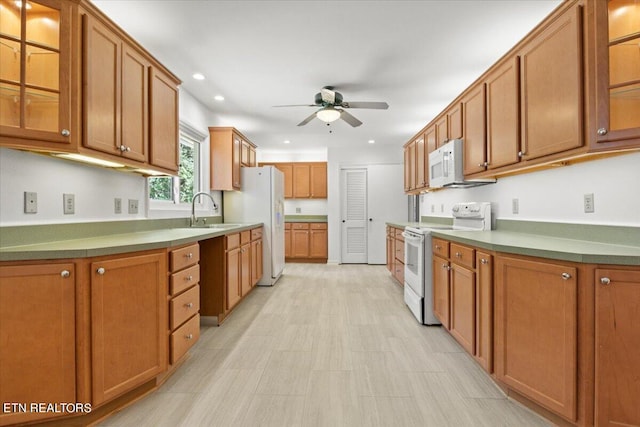 kitchen with white appliances, sink, and ceiling fan