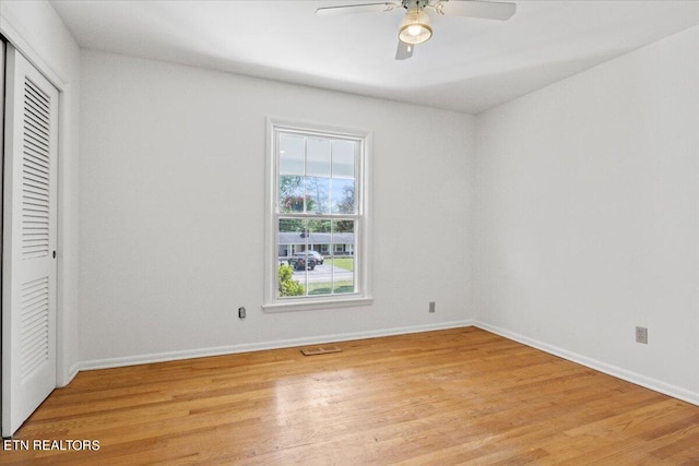 unfurnished bedroom featuring light hardwood / wood-style flooring, ceiling fan, and a closet