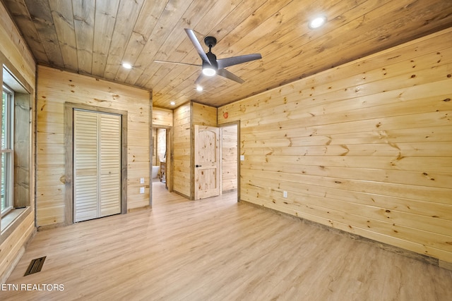 unfurnished bedroom featuring wood walls, wood ceiling, ceiling fan, and light hardwood / wood-style flooring