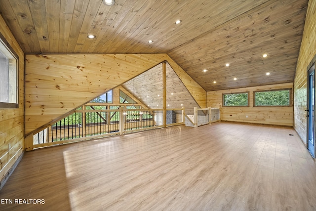 bonus room with wooden walls, wood-type flooring, vaulted ceiling, and wooden ceiling