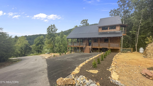 log-style house featuring covered porch