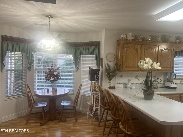 dining room with a wealth of natural light, a chandelier, and light wood-type flooring