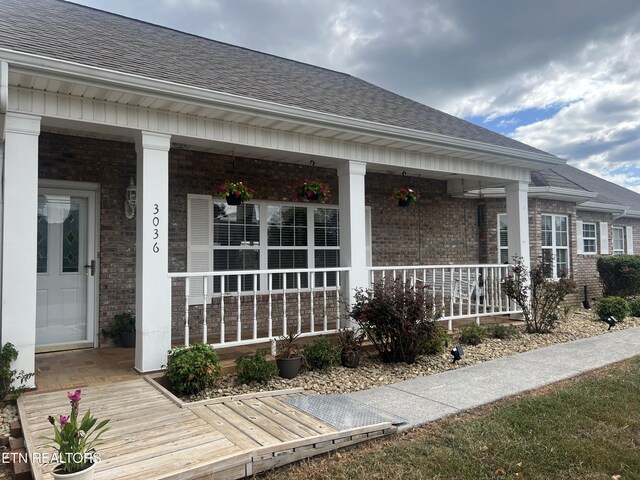 view of exterior entry featuring covered porch