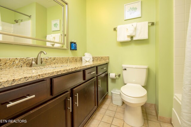 full bathroom with tile patterned floors, toilet, shower / bath combo with shower curtain, and vanity