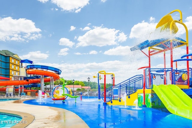 view of jungle gym with pool water feature and a community pool