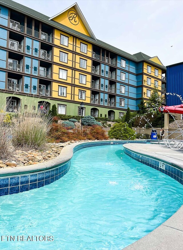 view of swimming pool with pool water feature