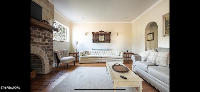 living room with a brick fireplace, hardwood / wood-style flooring, and crown molding