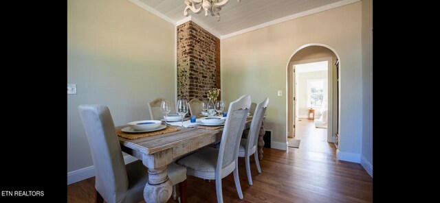 dining room with vaulted ceiling, dark hardwood / wood-style floors, ornamental molding, and a chandelier