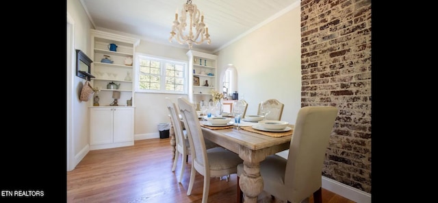 dining area featuring ornamental molding, vaulted ceiling, an inviting chandelier, and light hardwood / wood-style flooring