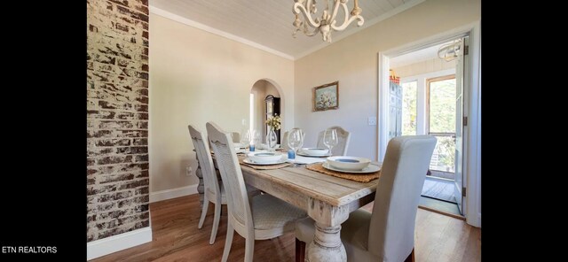 dining space with an inviting chandelier, hardwood / wood-style floors, and crown molding