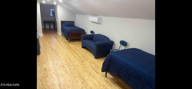 bedroom with light wood-type flooring and vaulted ceiling