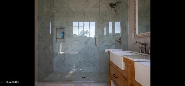 bathroom with vanity and a shower with door