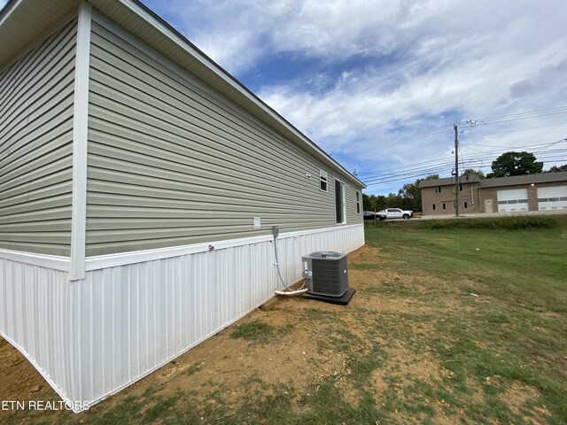 view of property exterior featuring a lawn and central AC