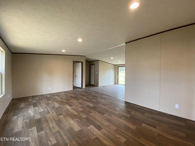 unfurnished room with a textured ceiling and dark wood-type flooring