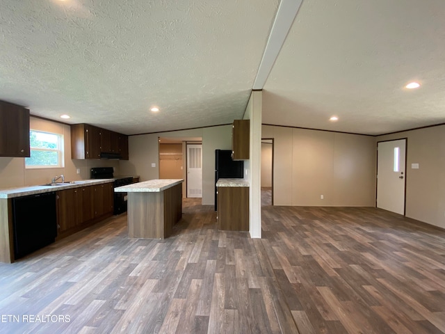 kitchen with a textured ceiling, dark wood-type flooring, black electric range, lofted ceiling, and a kitchen island